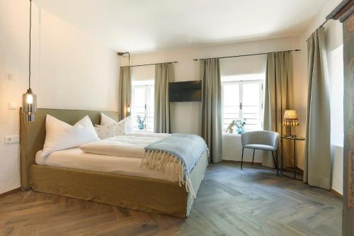 a bedroom with a large bed and a chair at Townhouse by Frauenzimmer in Abtenau