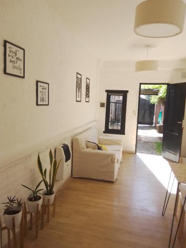 een woonkamer met een witte bank en een aantal planten bij Duplex, Córdoba zona norte in Cordoba