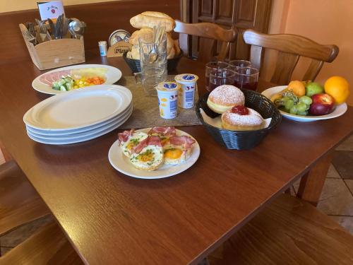 a wooden table topped with plates and bowls of food at Apartmanový dům 13 Podkroví 1 in Seč