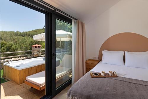 a bedroom with a bed and a balcony with a tub at Kairos Hotel in Kas