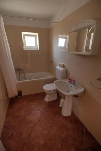 a bathroom with a toilet and a sink and a tub at Kaka in Sveti Juraj