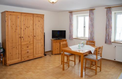a living room with a wooden table and a television at Weinhaus Kurtrierer Hof in Leiwen