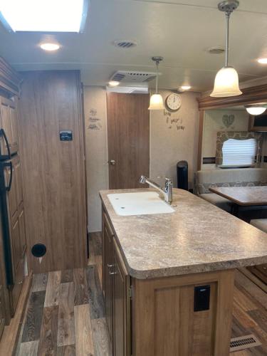 uma cozinha com um lavatório e uma bancada em Cozy Camper em Miami