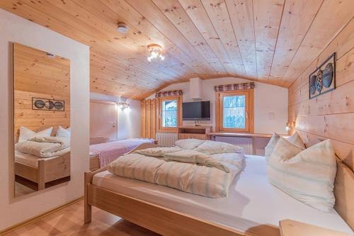 a bedroom with two beds in a room with wooden ceilings at Landhaus Biermeier in Sankt Gallenkirch