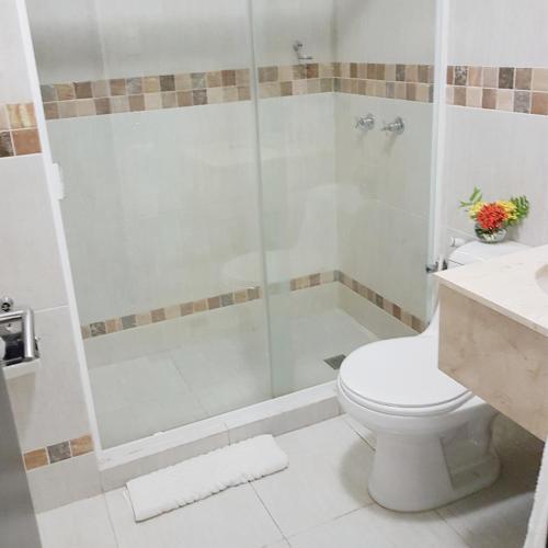 a bathroom with a shower with a toilet and a sink at Hotel Margarita Dynasty in Porlamar