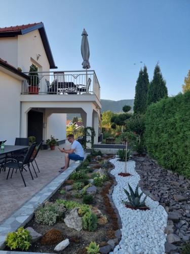 a man sitting in front of a house at Apartmani Markešić Ramsko jezero in Prozor