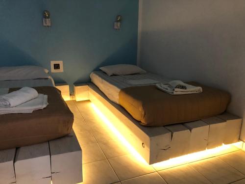 two beds in a room with lights on the floor at Mariu Canal d' Amour in Melíssia