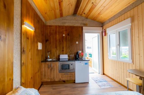 a kitchen with wooden walls and a white refrigerator at El horreo in Mazaricos