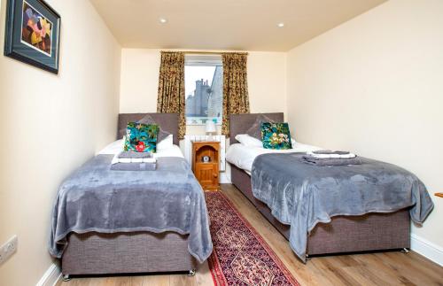 a bedroom with two beds and a window at Finest Retreats - Number Seven in Skipton