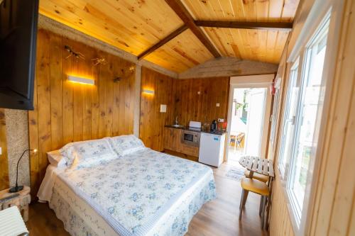 a bedroom with a bed in a room with wooden walls at El horreo in Mazaricos