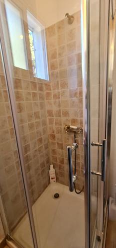 baño con ducha y puerta de cristal en Casa La Morada en El Paso