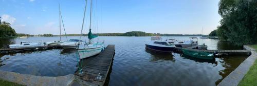 a group of boats docked at a dock on a lake at Mieszkanie nad jeziorem z własną linią brzegową in Iława