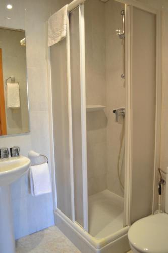 a bathroom with a shower and a toilet and a sink at Hostal Bartis in Figueres