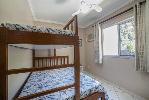 una camera con due letti a castello e una finestra di Apto 22E ar condicionado e ventilador, 2 quartos, churrasqueira, elevador e piscina a Ubatuba
