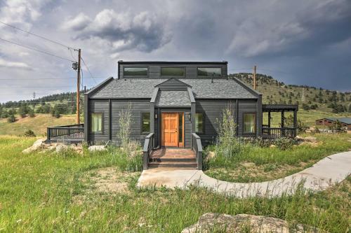 a black house on top of a grassy hill at Modern Evergreen Duplex Off I-70 with Mountain Views in Idaho Springs