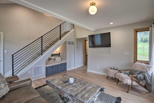 a living room with a staircase and a table at Modern Evergreen Duplex Off I-70 with Mountain Views in Idaho Springs
