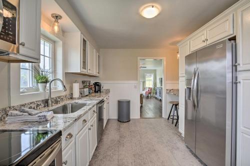 a kitchen with white cabinets and a stainless steel refrigerator at Idyllic Getaway with Deck about 4 Mi to Dtwn Athens in Athens