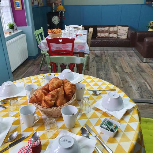 a table with a basket of croissants on it at Chambres Dhôtes Numéro 1 in Châteaulin