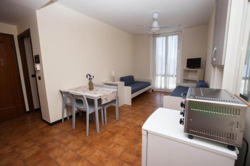 una cucina e un soggiorno con un tavolo e un divano di Residence RTA Villa Marina a Imperia