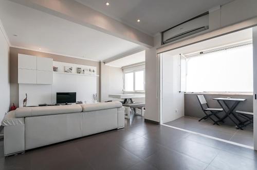 a large white room with a couch and a table at Amazing Apartment in Costa da Caparica in Costa da Caparica