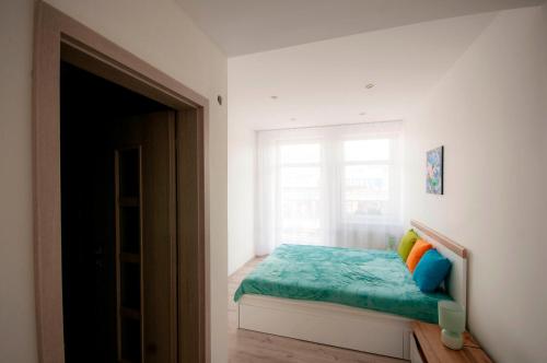 a bedroom with a bed with a window at MAYTEX - ubytovanie v 46m2 apartmáne s balkónom in Liptovský Mikuláš