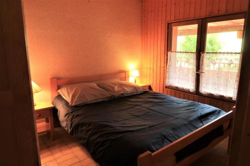 a bedroom with a bed and a window in a room at CHARMIEUX appartement en chalet typique in Le Grand-Bornand