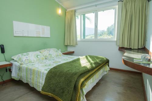 um pequeno quarto com uma cama e uma janela em Pousada Verbicaro em Santa Maria Madalena
