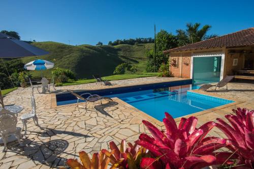 einen Pool mit Terrasse und ein Haus in der Unterkunft Pousada Verbicaro in Santa Maria Madalena