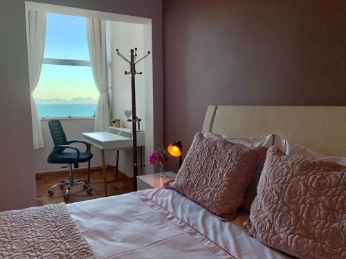 1 dormitorio con 1 cama, escritorio y ventana en Copacabana Sea View Apartament, en Río de Janeiro