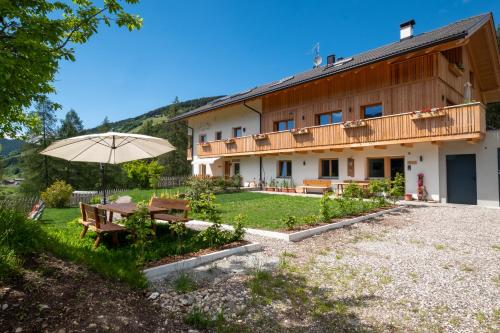 a house with a picnic table and an umbrella at Apartments Kaserott in Villnoss