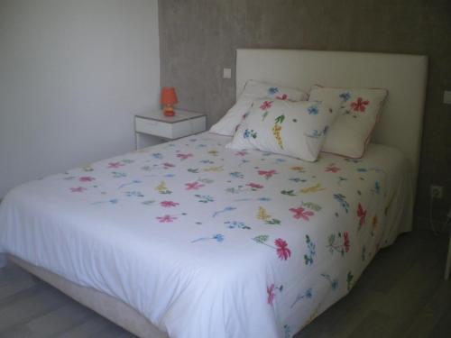 Montcuq的住宿－Maison de campagne MONTCUQ en Quercy Blanc，卧室配有带鲜花的白色床