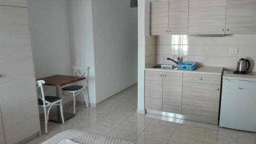 a kitchen with a sink and a table in it at Anatoli Rooms in Aegiali