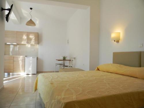 a bedroom with a large bed and a kitchen at Anatoli Rooms in Aegiali
