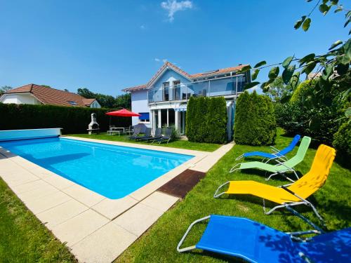 une cour avec des chaises et une piscine dans l'établissement Villa with Pool - Leon's Holiday Homes, à Dottikon