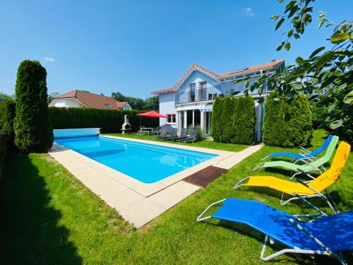 a swimming pool in the yard of a house at Villa with Pool - Leon's Holiday Homes in Dottikon