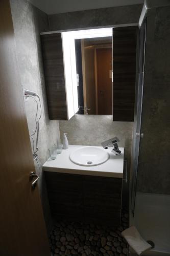 uma casa de banho com um lavatório e um espelho em H2O em Zalakaros