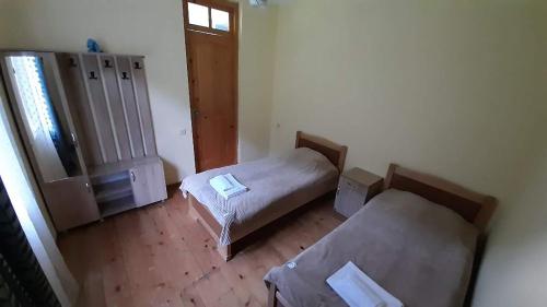 a small room with two beds and a window at Guest house-Lile in Mestia