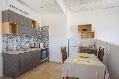 una cucina con tavolo, lavandino e frigorifero di Bay View Suites a Vassiliki