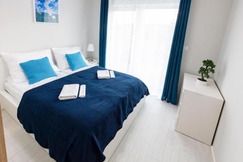 sypialnia z dużym łóżkiem z niebieskimi prześcieradłami w obiekcie Apartament 7M z Basenem w jednym budynku Rewal, free private parking, Park rozrywki HOSSOLAND 30 minut w Rewalu