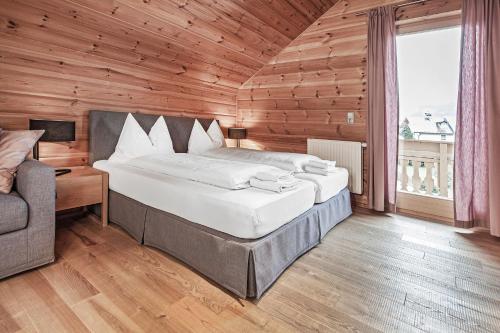 a bedroom with a large bed in a wooden room at Chalet Dacha mit finnischer Sauna in Zell am See