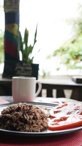 a plate of food and a cup of coffee on a table at Miguel Surf Camp in Quepos