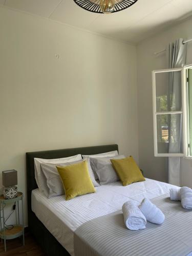 - une chambre avec 2 lits dotés d'oreillers jaunes et blancs dans l'établissement Via De Bosset City Cottage, à Argostóli