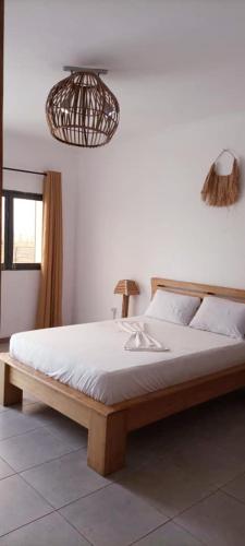 a bedroom with a large bed with white sheets at Villa Saint-Sulpice Apt avec piscine in Yaoundé