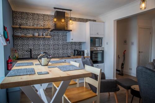 cocina y comedor con mesa y sillas en Great Glen Way Canal Side Apartment, en Inverness