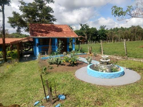 a blue house with a fountain in a yard at chaler Sao Jorge in São Pedro