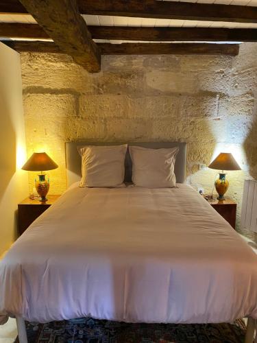 a bedroom with a large white bed with two lamps at 16 CHEMIN DE BOISBELET in Coutras