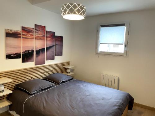1 dormitorio con cama y ventana en Très bel appartement T2 de standing entièrement meublé à 5 min à pied du centre. en Divonne-les-Bains