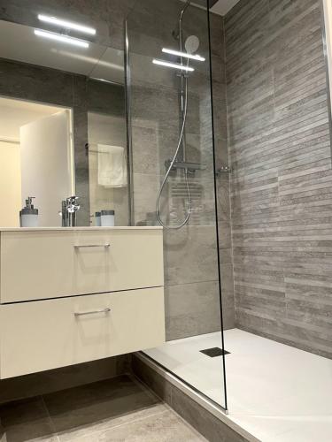 y baño con ducha y lavamanos. en Très bel appartement T2 de standing entièrement meublé à 5 min à pied du centre. en Divonne-les-Bains