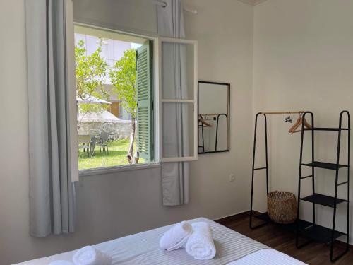 - une chambre avec des serviettes sur un lit et une fenêtre dans l'établissement Via De Bosset City Cottage, à Argostóli