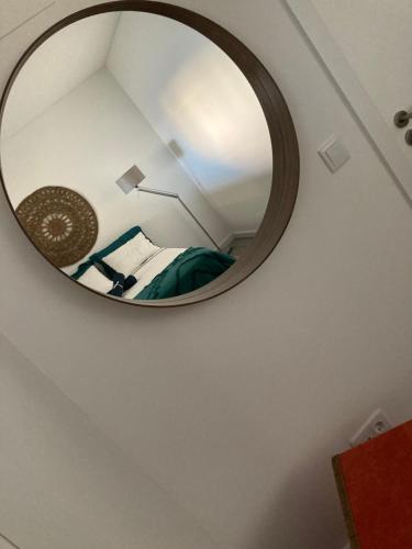 a mirror in a room with a bed and a lamp at Sesimbra by the sea in Sesimbra
